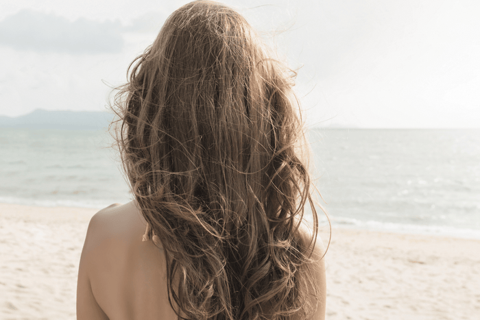 FFOR Hair woman on beach with hair blowing in the wind