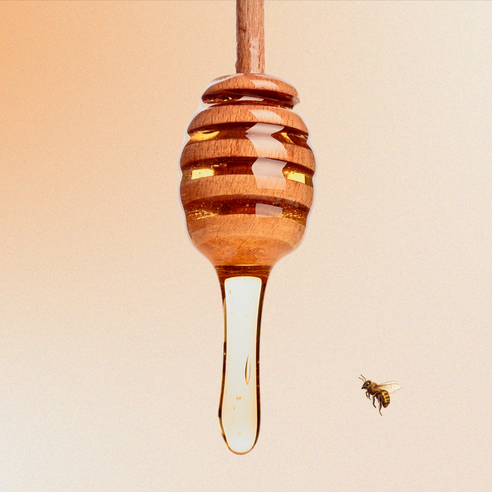 Honey dripping off a honey spoon with bee buzzing around