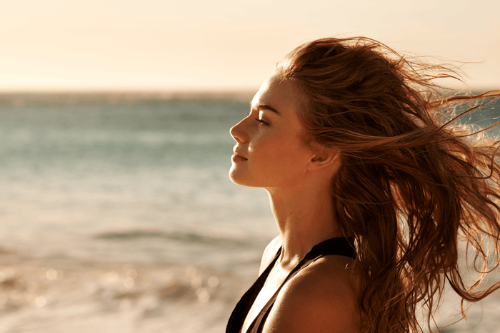 woman on beach with hair blowing in the wind