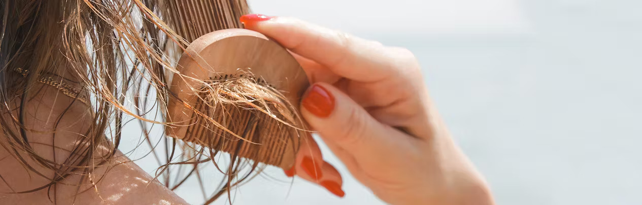 FFOR Hair banner image with close up of woman out in the sun brushing wet hair with comb