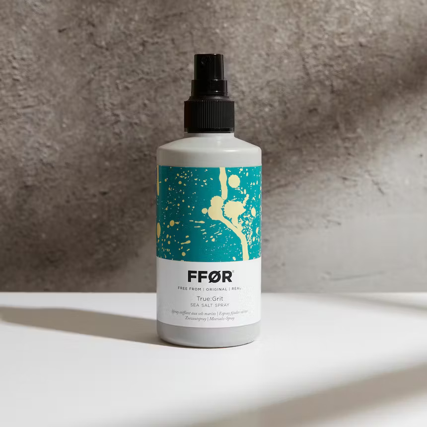 FFOR Hair bottle of true grit sea salt spray on plain backdrop